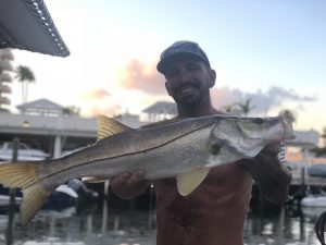 Happy angler holding a nice snook he just caught in Fort Lauderdale.