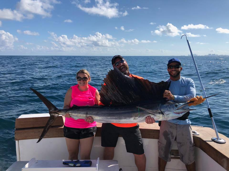 Couple holding a big sailfish just landed on our Fort Lauderdale deep sea fishing charter.